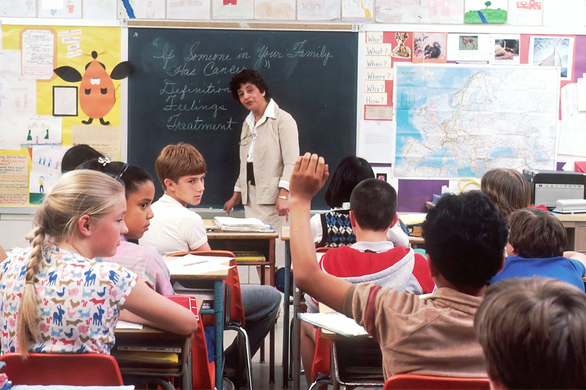 Children raising their hands in class
